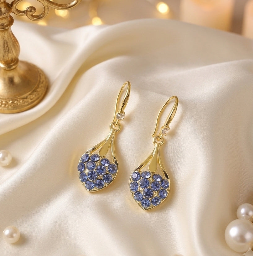 Blue crystal heart drop earrings gold tone on white silk with pearls and candle