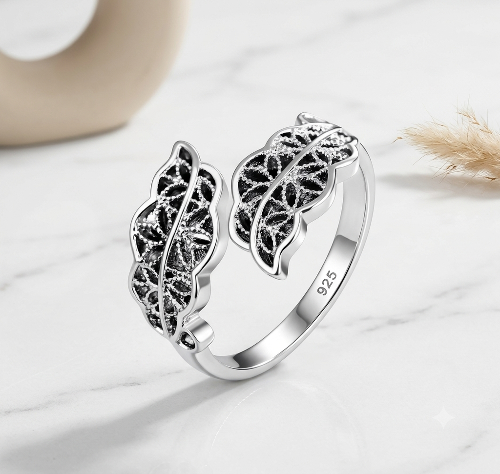 Adjustable silver leaf ring on dark blue fabric background