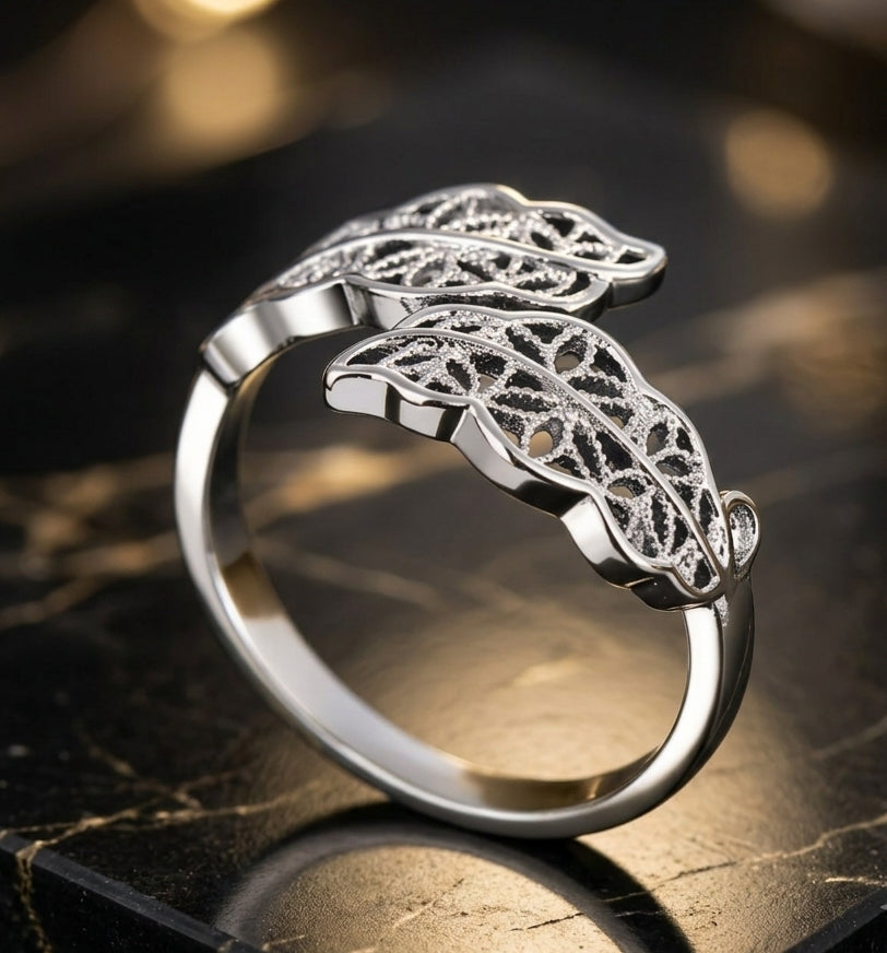 Adjustable silver leaf filigree ring on dark marble surface