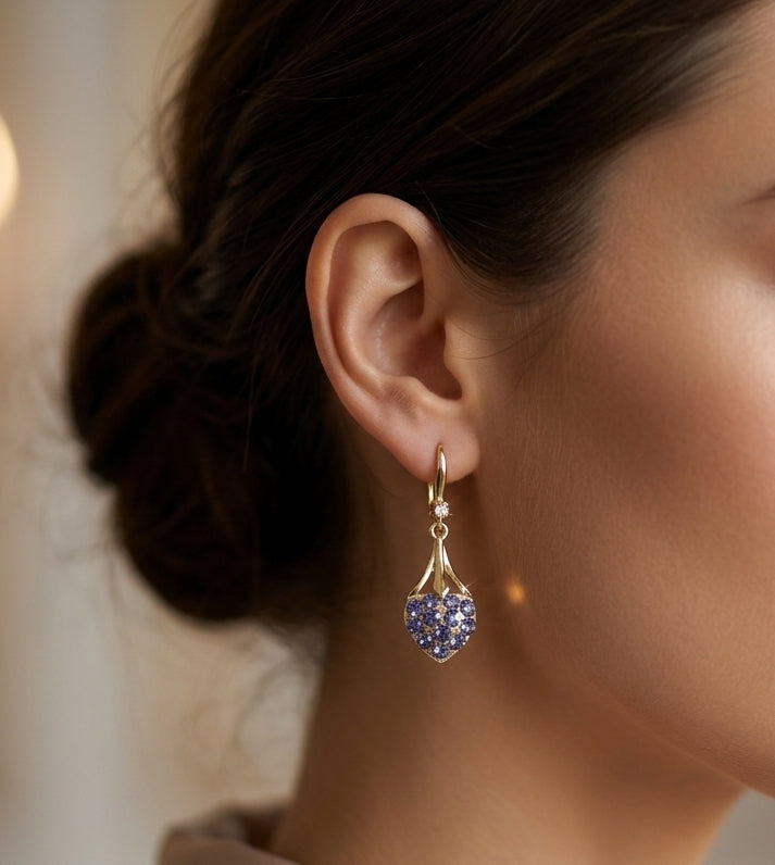 Model wearing blue crystal heart drop earrings gold tone elegant side profile